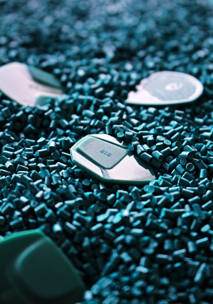 Mastering the First Impression: Your intriguing post title goes here Detailed view of green guitar picks surrounded by textured plastic pellets.