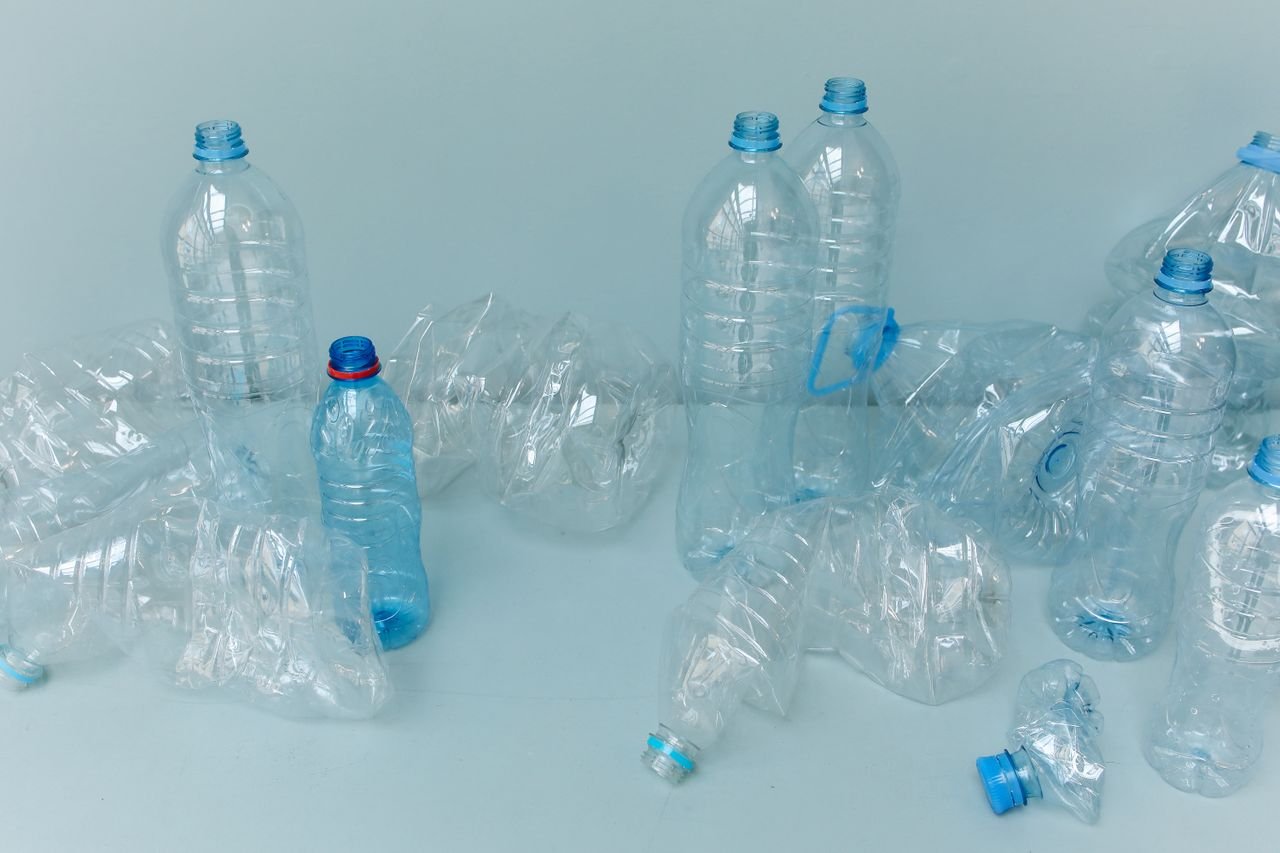 A collection of crumpled plastic bottles arranged on a white studio background.